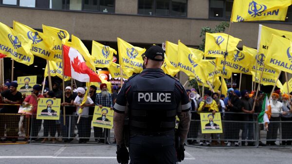 Police officers stand guard as Pro-Khalistan supporters gather for a demonstration in front of the Indian Consulate in Toronto, Ontario, Canada on July 8, 2023.  - Sputnik भारत