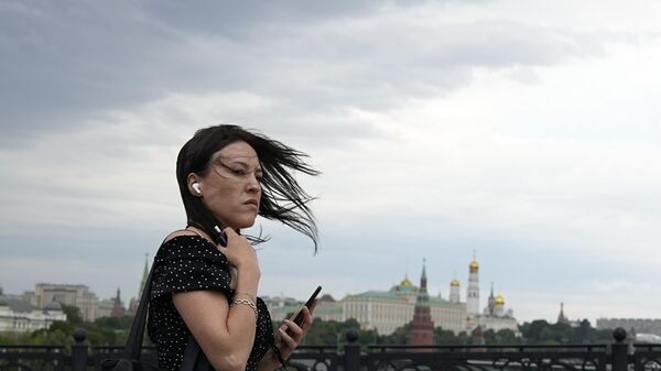 A woman's hair is been tousled while she is crossing the Patriarshy bridge in Moscow, Russia, Friday, July, 5, 2024. (AP Photo/Pavel Bednyakov) - Sputnik India