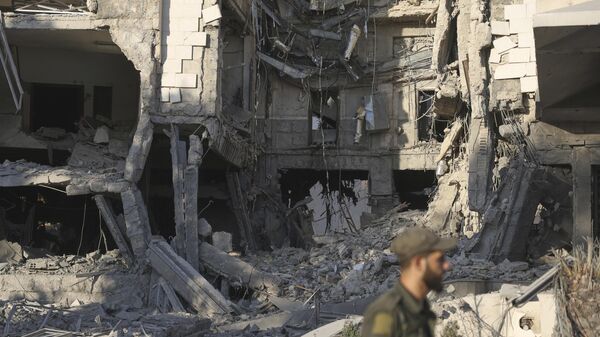 A soldier passes in front the damaged Syrian Defense Ministry building allegedly hit by several Israeli airstrikes, in Damascus, Syria, Wednesday, July 16, 2025. (AP Photo/Ghaith Alsayed) - Sputnik India