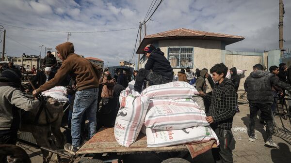 Displaced Palestinians receive food aid at the United Nations Relief and Works Agency for Palestine Refugees (UNRWA) center in Rafah in the southern Gaza Strip on January 28, 2024, amid ongoing battles between Israel and the Palestinian militant group Hamas - Sputnik India