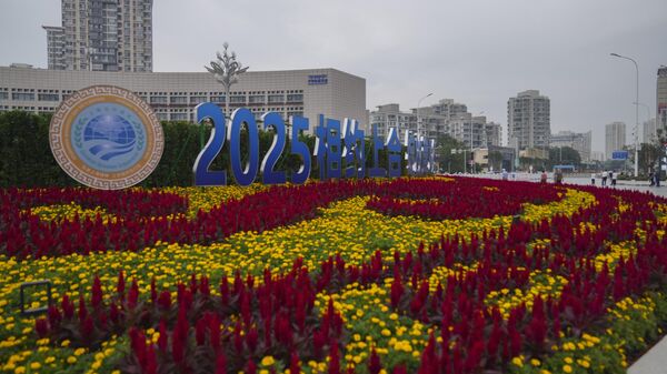 People walks past the logo of the Shanghai Cooperation Organisation (SCO) summit outside a train station in Tianjin, China , Friday, Aug. 29, 2025. - Sputnik India