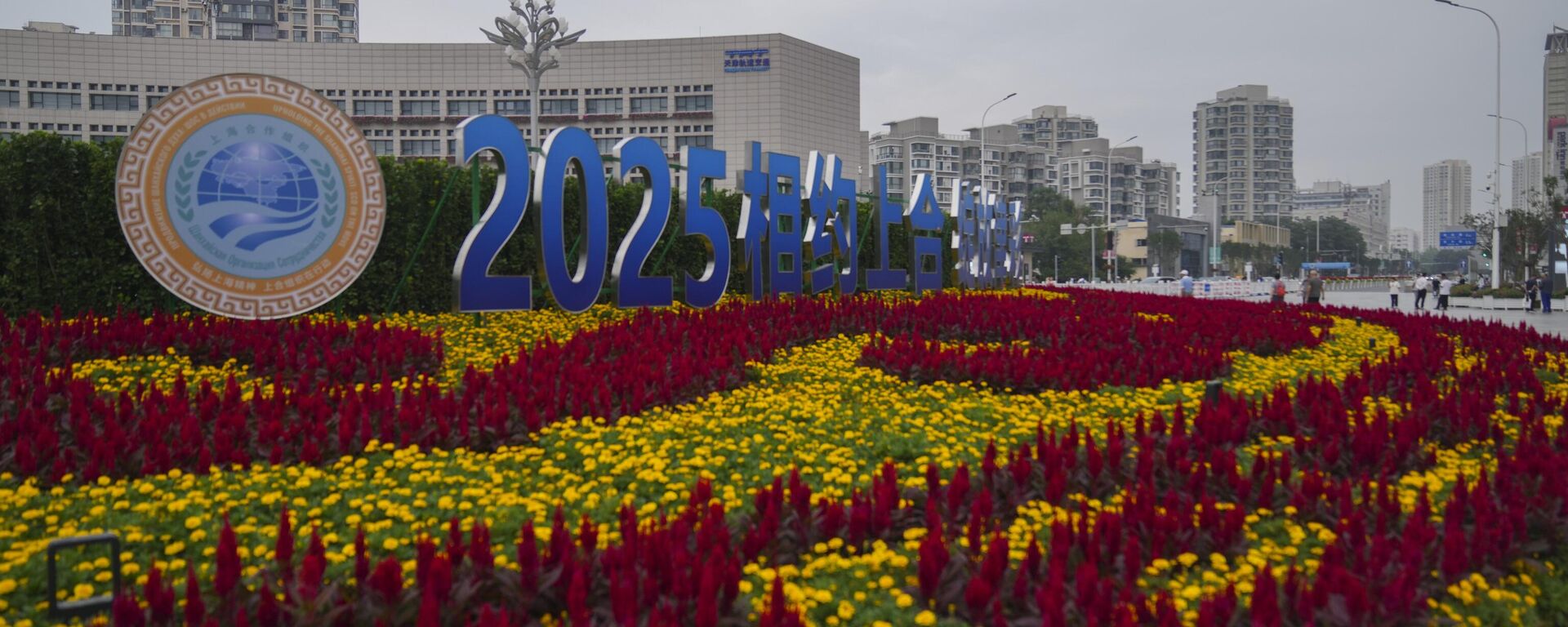 People walks past the logo of the Shanghai Cooperation Organisation (SCO) summit outside a train station in Tianjin, China , Friday, Aug. 29, 2025. - Sputnik India, 1920, 30.08.2025