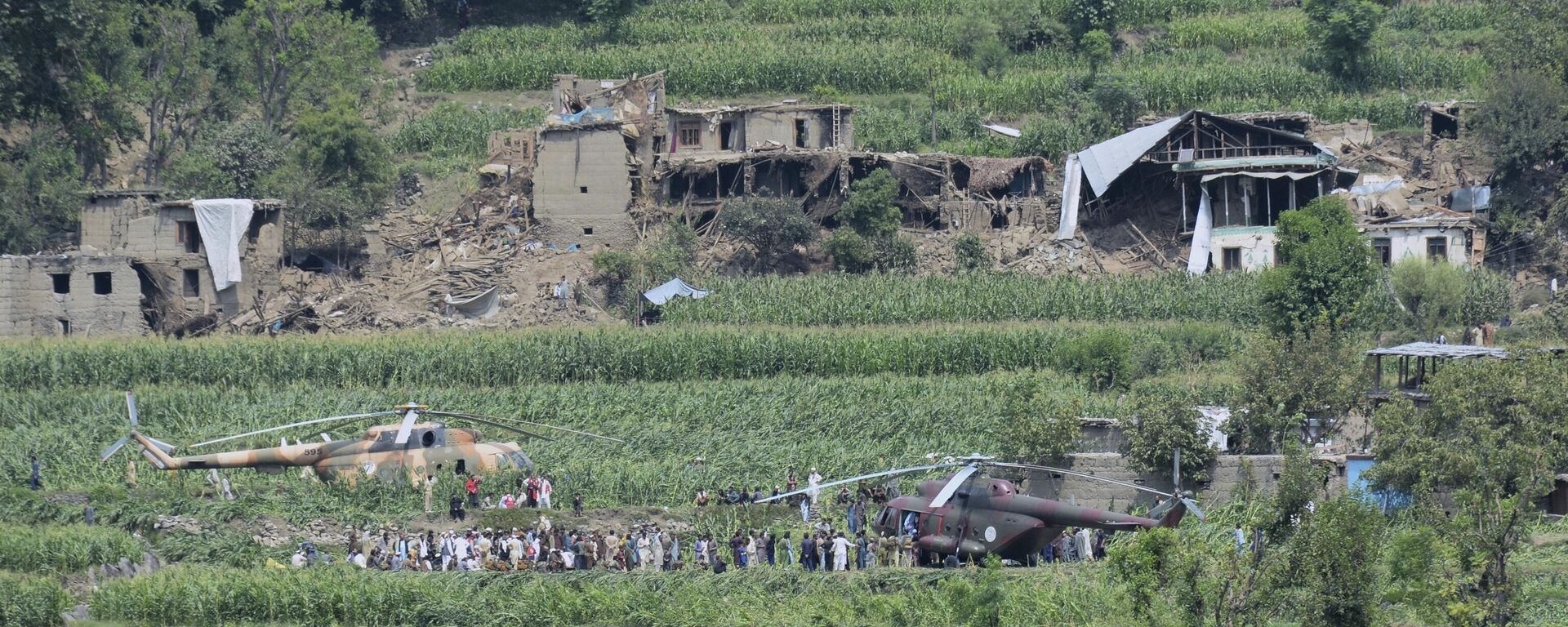 Local residents gather around military helicopters that landed to provide help and evacuate injured victims of an earthquake that killed many people and destroyed villages in eastern Afghanistan, in Mazar Dara, Kunar province, Afghanistan, Monday, Sept. 1, 2025.  - Sputnik भारत, 1920, 01.09.2025
