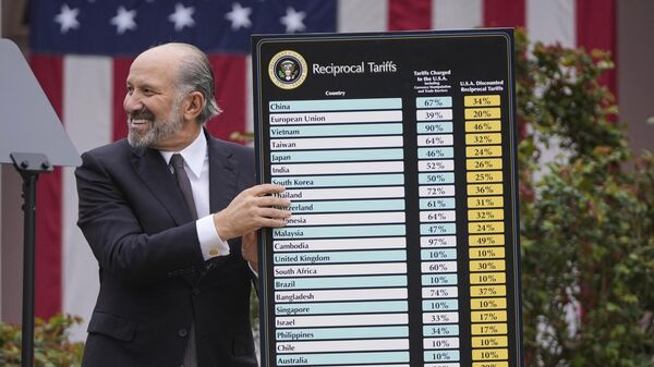 Commerce Secretary Howard Lutnick holds a chart as President Donald Trump speaks during an event to announce new tariffs in the Rose Garden at the White House, Wednesday, April 2, 2025, in Washington - Sputnik India