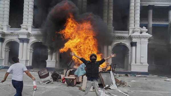 Protesters celebrate at the Singha Durbar, the seat of Nepal's government's various ministries and offices, after it was set on fire during a protest against social media ban and corruption in Kathmandu, Nepal, Tuesday, Sept. 9, 2025.  - Sputnik भारत
