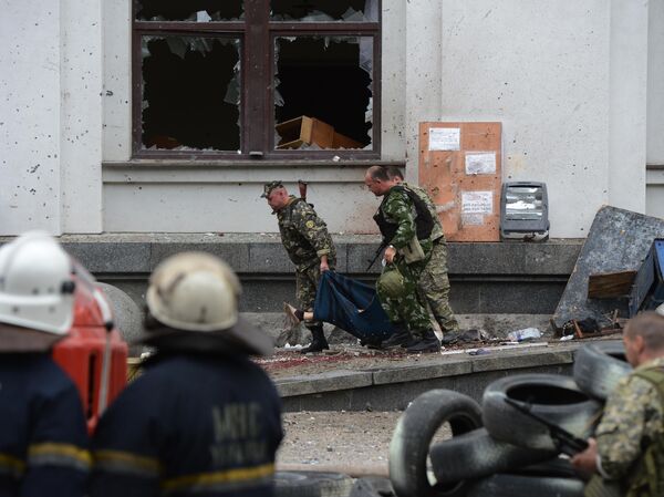 Milicianos populares transportan a una víctima mortal del ataque aéreo de la Fuerza Aérea de Ucrania contra el edificio de la administración regional en Lugansk - Sputnik भारत