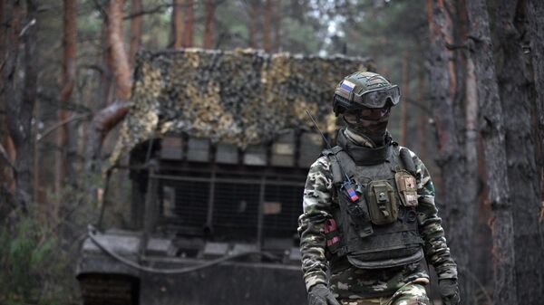A Russian serviceman walks next to the TOS-1A Solntsepyok thermobaric rocket launcher at a position amid Russia's military operation. - Sputnik भारत