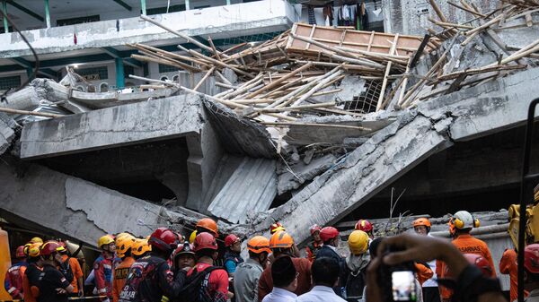 SIDOARJO, EAST JAVA, INDONESIA - SEPTEMBER 30: Indonesia National Search and Rescue Agency officers search for survivors in the rubble of a collapsed building at Al Khoziny Islamic Boarding School on September 30, 2025 in Sidoarjo, East Java, Indonesia. Islamic Boarding School Al Khoziny Buduran Sidoarjo collapsed trapping dozens of students while performing Asr prayers. Indonesia National Search and Rescue Agency reported that one student died and 84 others suffered minor to serious injuries and were referred to Siti Hajar Islamic Hospital and Sidoarjo Regional Hospital. Search and evacuation efforts for buried victims are still being carried out. (Photo by Robertus Pudyanto/Getty Images) - Sputnik India