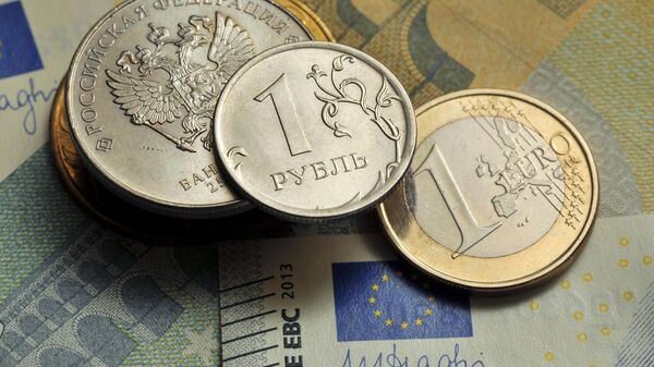Coins of 1 ruble and 1 euro against the background of a 5 euro banknote. - Sputnik India
