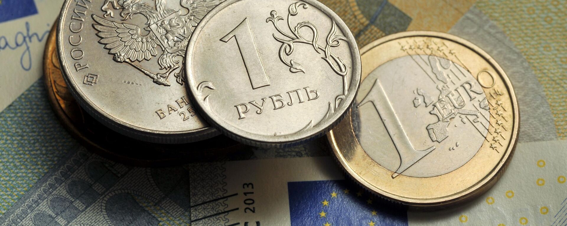 Coins of 1 ruble and 1 euro against the background of a 5 euro banknote. - Sputnik भारत, 1920, 01.10.2025