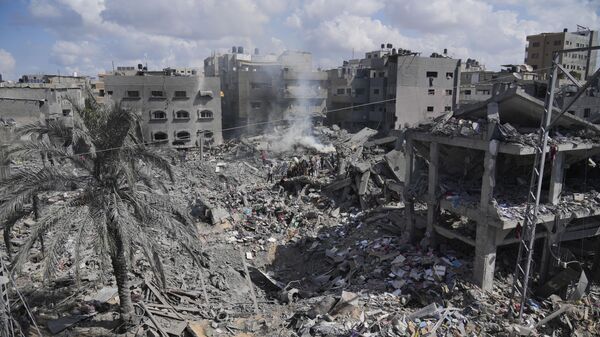 Palestinians search for the people killed in an Israeli airstrike in Bureij refugee camp Gaza Strip, Wednesday, Oct. 18, 2023 - Sputnik India