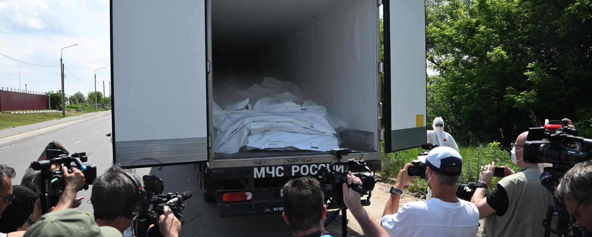 Foreign journalists film a refrigerated truck in a convoy carrying the bodies of 1,212 bodies of the Ukrainian Armed Forces servicemen in the Bryansk region, Russia.  - Sputnik India, 1920, 23.10.2025