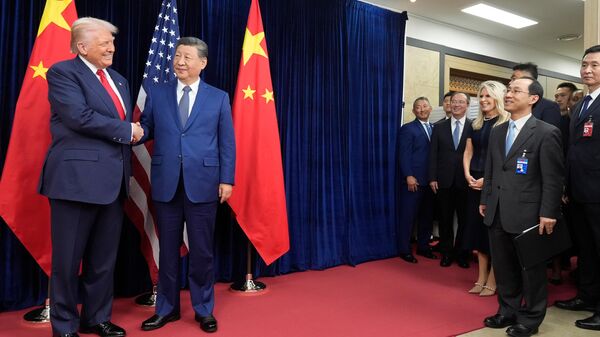 President Donald Trump, left, and Chinese President Xi Jinping shake hands before their meeting at Gimhae International Airport in Busan, South Korea, Thursday, Oct. 30, 2025.  - Sputnik भारत