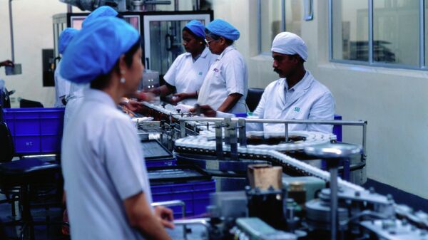 Workers watch drugs flow through the assembly line of the SmithKline Beecham pharmaceutical factory in Bangladore, India. - Sputnik भारत