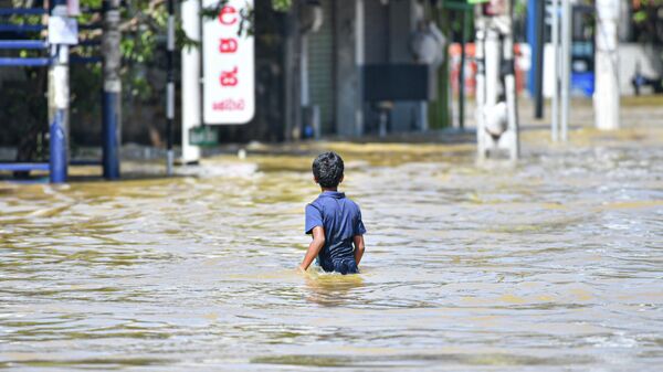 A young child walks through floodwaters after heavy rains from Cyclone ''Ditwah'' cause widespread flooding on November 30, 2025.  - Sputnik भारत