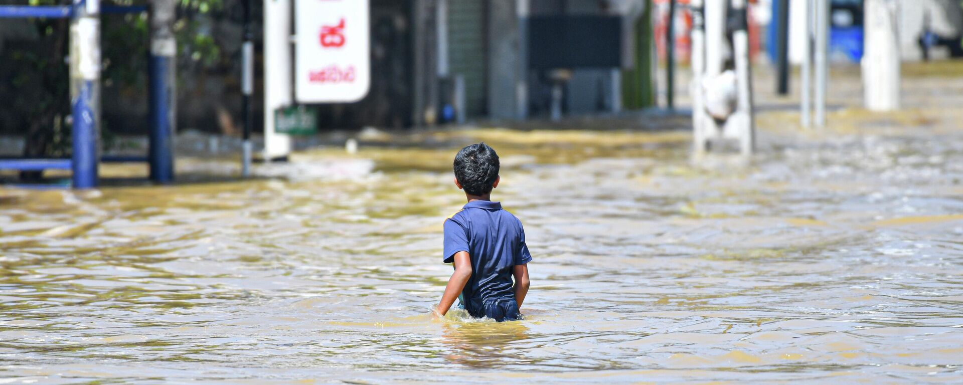 A young child walks through floodwaters after heavy rains from Cyclone ''Ditwah'' cause widespread flooding on November 30, 2025.  - Sputnik भारत, 1920, 02.12.2025