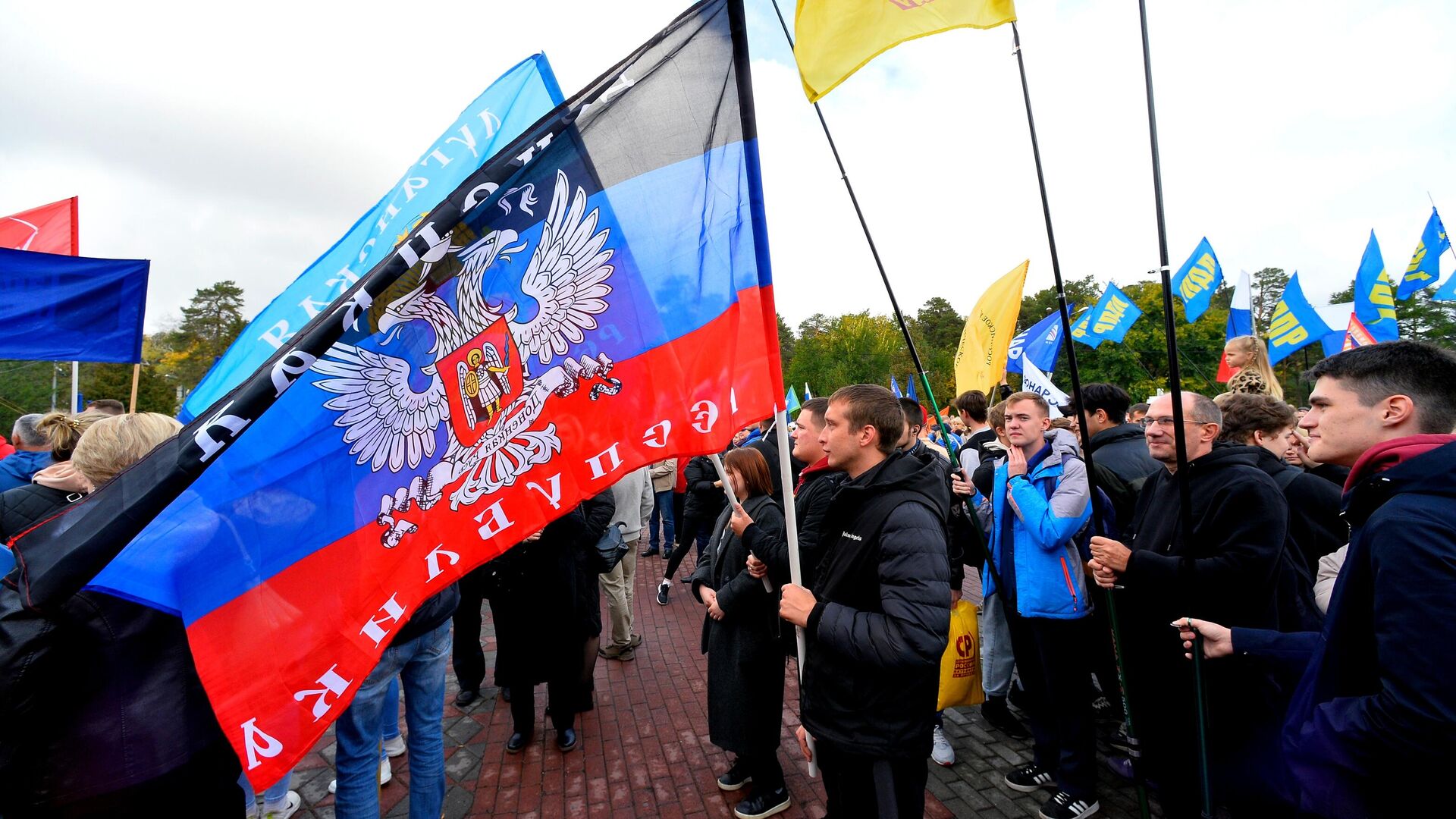 People wave flags during a concert on the day of new regions' reunification with Russia - Sputnik भारत, 1920, 12.12.2025