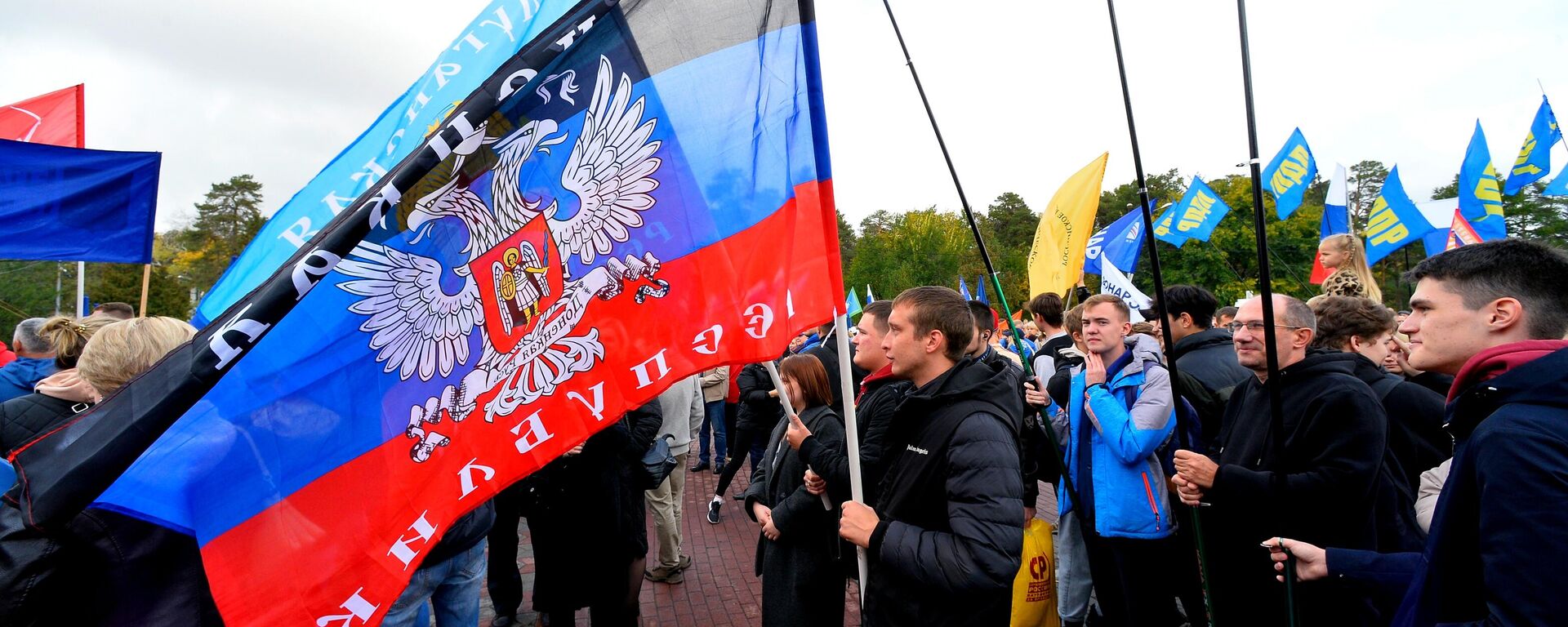 People wave flags during a concert on the day of new regions' reunification with Russia - Sputnik भारत, 1920, 12.12.2025