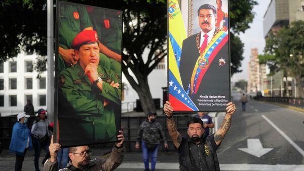 Government supporters display posters of Venezuelan President Nicolás Maduro, right, and former President Hugo Chávez in downtown Caracas, Venezuela, Saturday, Jan. 3, 2026. - Sputnik India