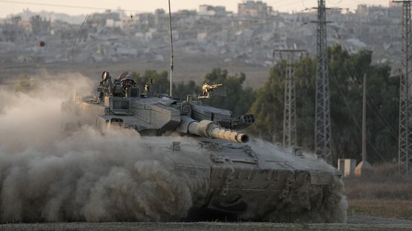 With destroyed buildings in the Gaza Strip behind him, an Israeli soldier waves from a tank, near the Israel-Gaza border in southern Israel, Thursday, Aug. 1, 2024.  - Sputnik India