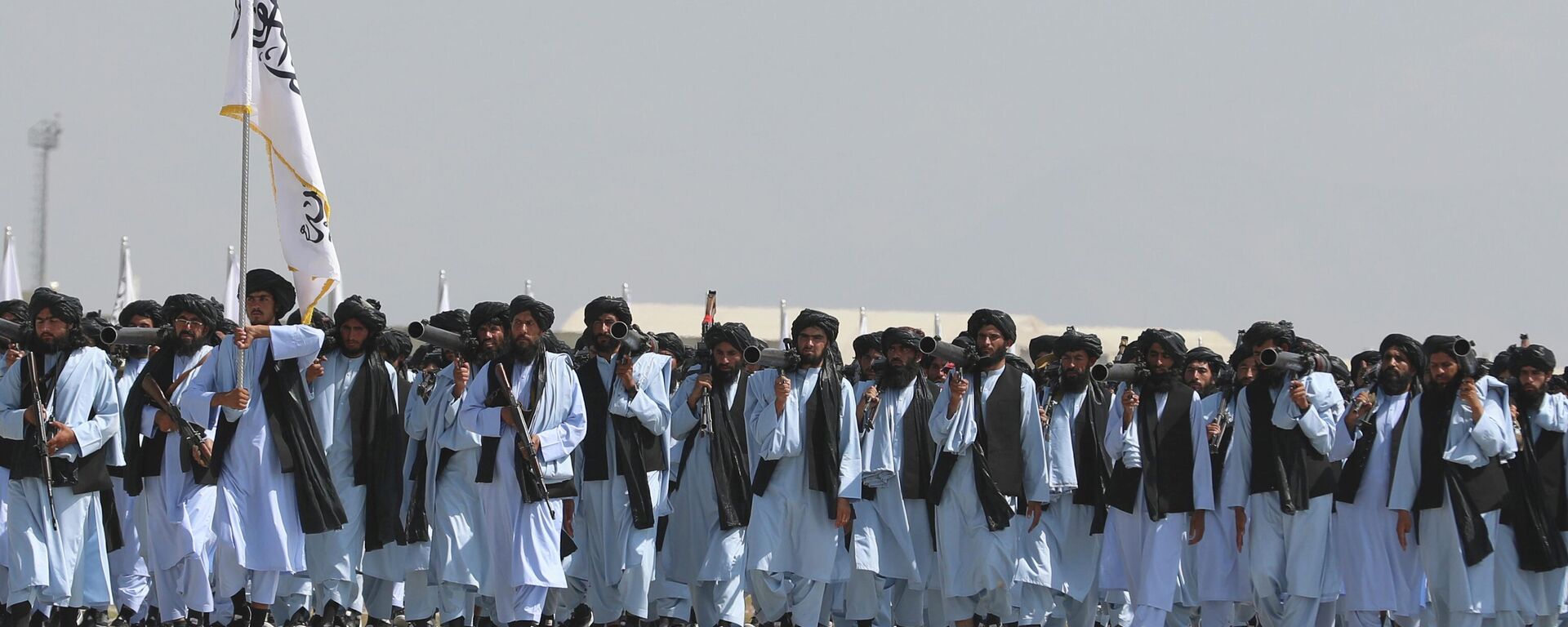 Taliban fighters march during a military parade to mark the third anniversary of the withdrawal of U.S.-led troops from Afghanistan, in Bagram Air Base in the Parwan Province of Afghanistan, Wednesday, Aug. 14, 2024. - Sputnik India, 1920, 13.01.2026