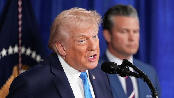 President Donald Trump speaks at his Mar-a-Lago club, Saturday, Jan. 3, 2026, in Palm Beach, Fla., as Defense Secretary Pete Hegseth listens - Sputnik भारत