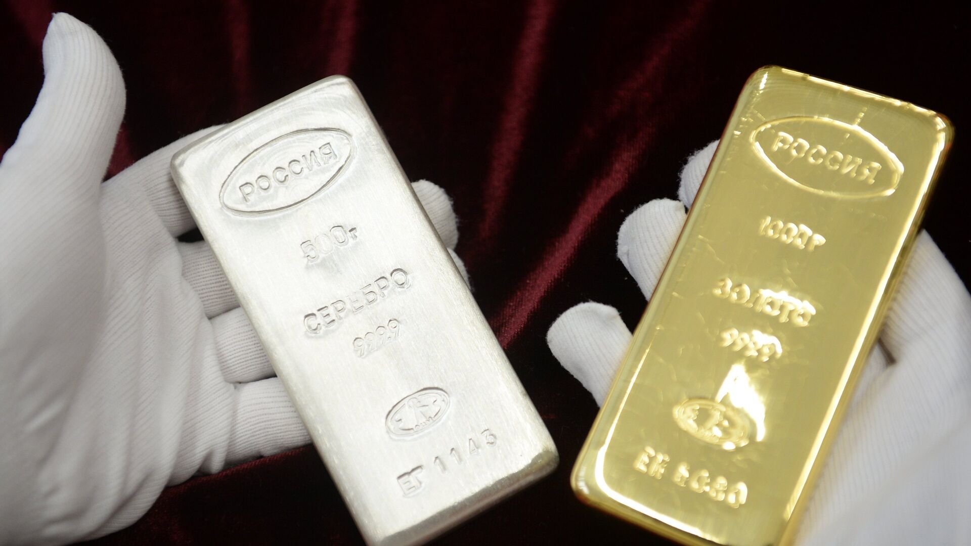 A worker holds a gold bar and a silver bar produced during the opening of a new bank bar manufacturing line at a plant in Yekaterinburg. - Sputnik India, 1920, 03.03.2026