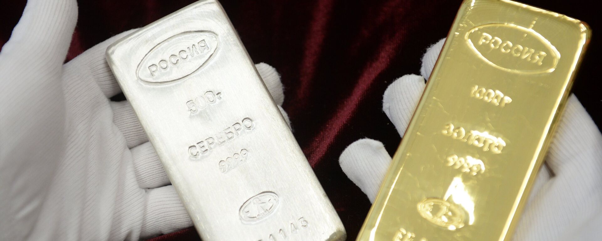 A worker holds a gold bar and a silver bar produced during the opening of a new bank bar manufacturing line at a plant in Yekaterinburg. - Sputnik भारत, 1920, 03.03.2026
