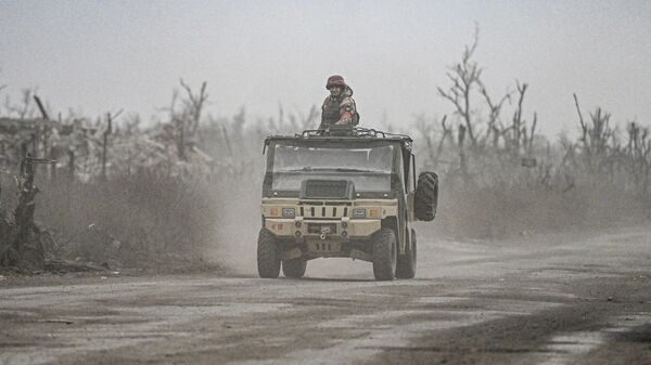 Russian servicemen drive a vehicle in the village of Karlovka, controlled by Russian armed forces, near Krasnoarmeysk  - Sputnik India