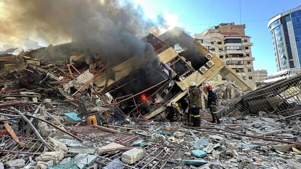 Members of the Lebanese Civil Defence inspect a damaged building after an Israeli strike on Beirut's southern suburbs, following renewed hostilities between Hezbollah and Israel amid the U.S.-Israeli conflict with Iran, Lebanon, March 9, 2026. Picture taken with a mobile phone. - Sputnik India