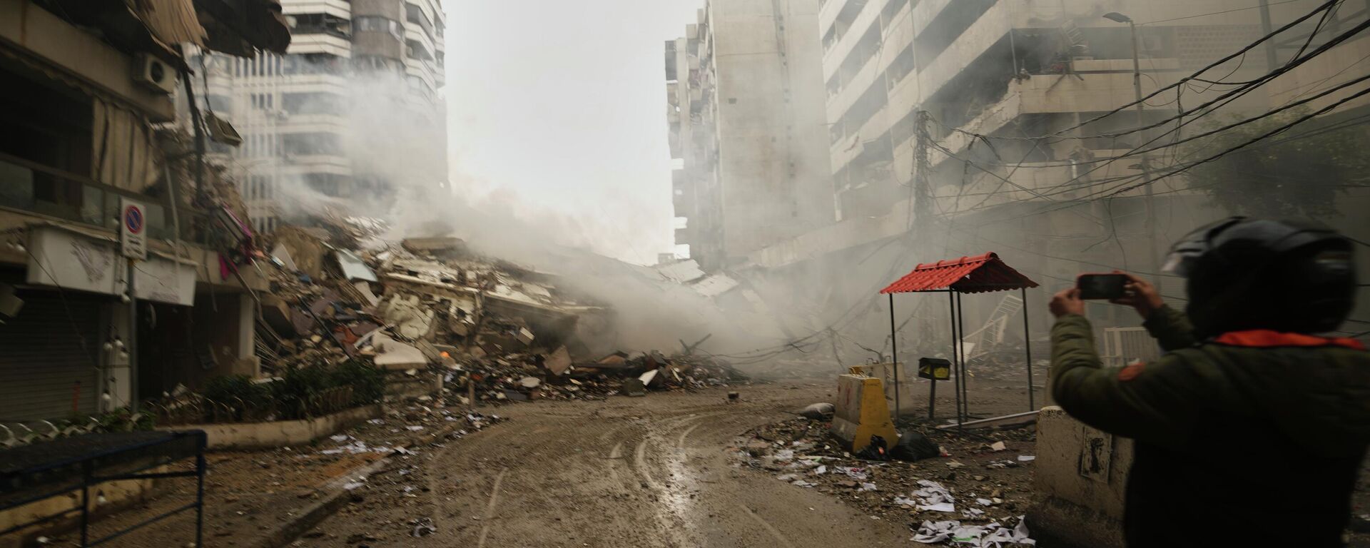 A man photographs the rubble of buildings destroyed in an Israeli airstrike in Dahiyeh, Beirut's southern suburbs, Lebanon, Sunday, March 15, 2026. (AP Photo/Hassan Ammar) - Sputnik भारत, 1920, 29.03.2026