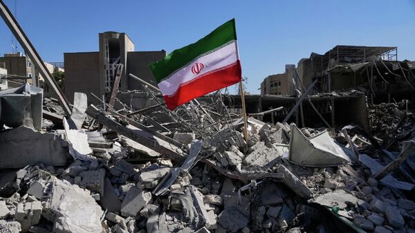 An Iranian flag is placed among the ruins of a police station struck Monday during the U.S.–Israeli military campaign in Tehran, Iran, Tuesday, March 3, 2026. (AP Photo/Vahid Salemi) - Sputnik India