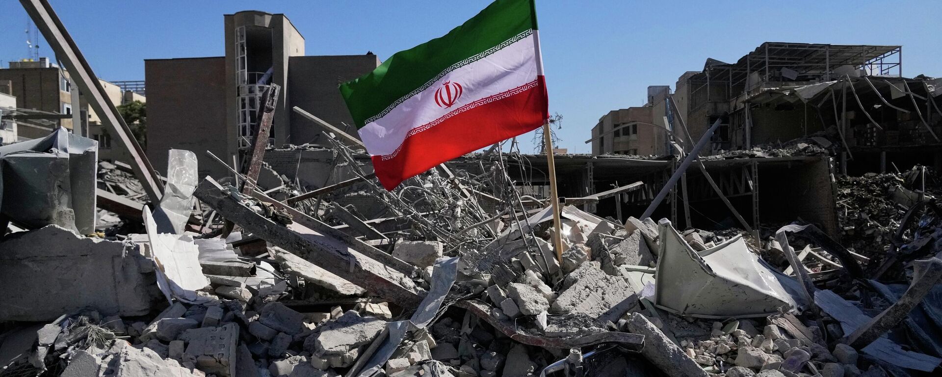 An Iranian flag is placed among the ruins of a police station struck Monday during the U.S.–Israeli military campaign in Tehran, Iran, Tuesday, March 3, 2026. (AP Photo/Vahid Salemi) - Sputnik भारत, 1920, 05.04.2026