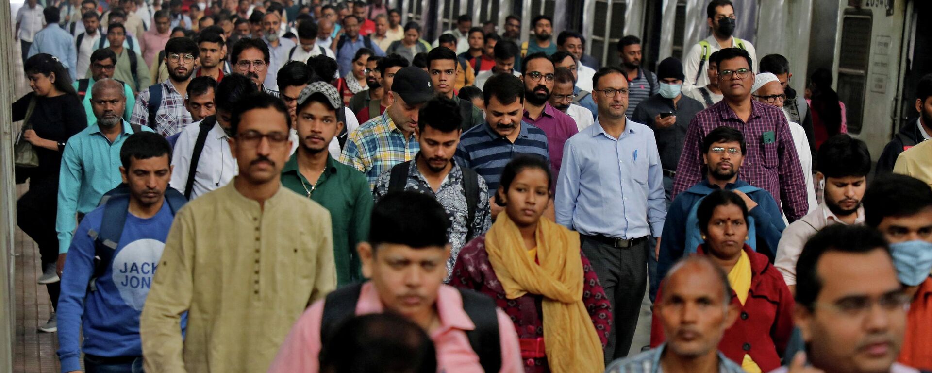 Commuters walk on a platform after disembarking from a suburban train at a railway station in Mumbai, India, January 21, 2023. - Sputnik भारत, 1920, 01.04.2026