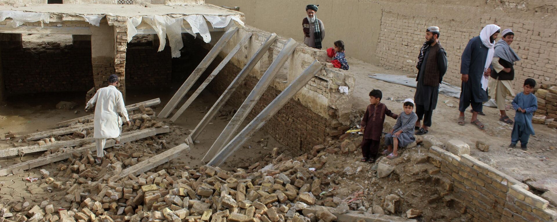 Locals inspect a damaged house following floods, landslides and thunderstorms in Kandahar province, Afghanistan, Sunday, March 29, 2026. - Sputnik भारत, 1920, 02.04.2026