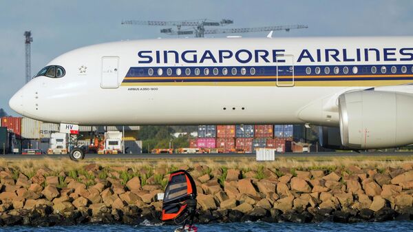 A man wing foils on Botany Bay as a Singapore Airlines passenger jet taxis after landing at Sydney Airport in Australia, Sept. 5, 2022. - Sputnik India