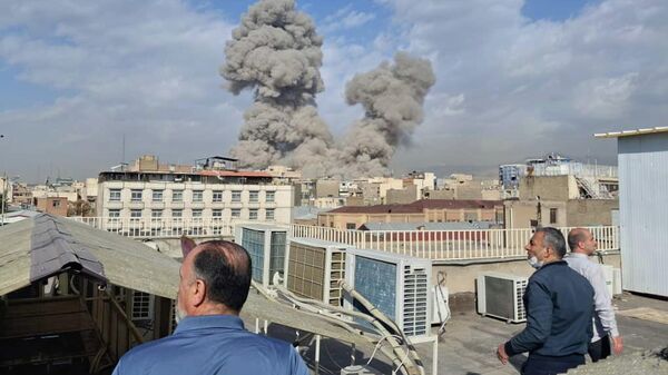 People watch as smoke rises on the skyline after an explosion in Tehran, Iran, Saturday, Feb. 28, 2026. - Sputnik भारत