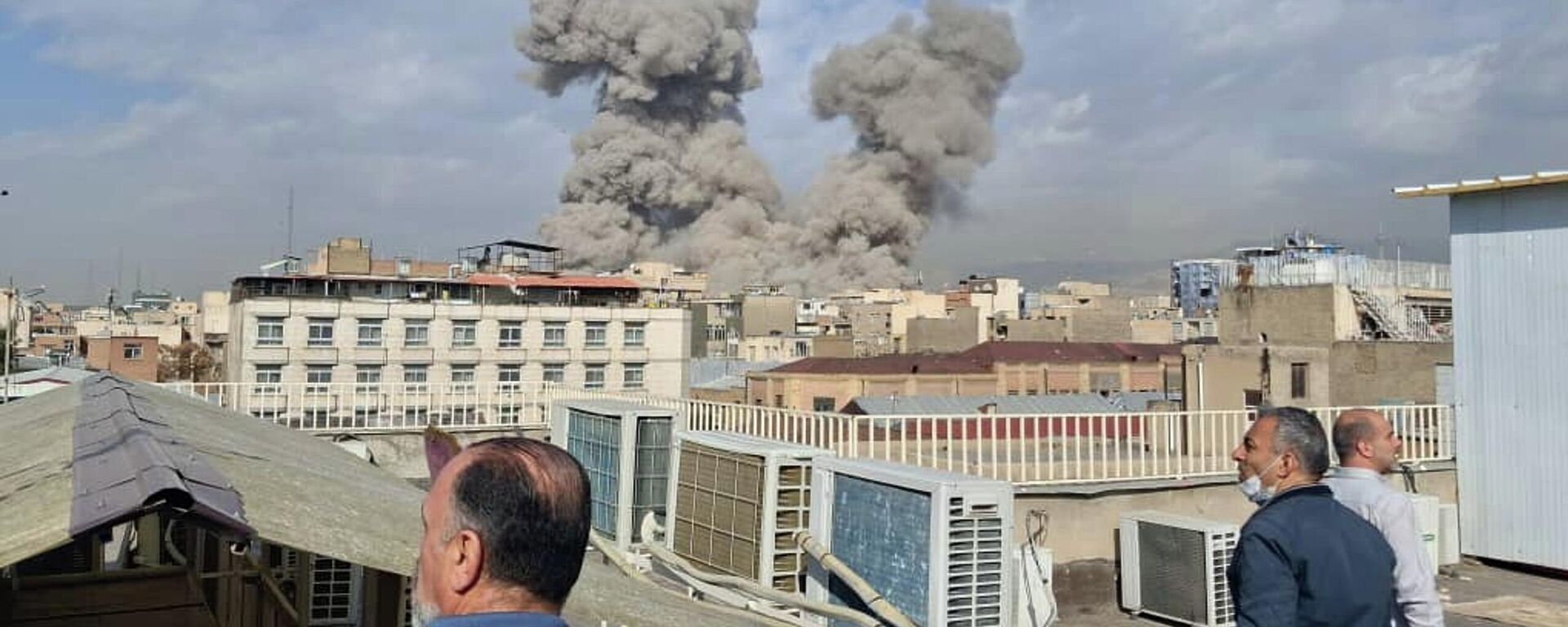 People watch as smoke rises on the skyline after an explosion in Tehran, Iran, Saturday, Feb. 28, 2026. - Sputnik भारत, 1920, 01.06.2026