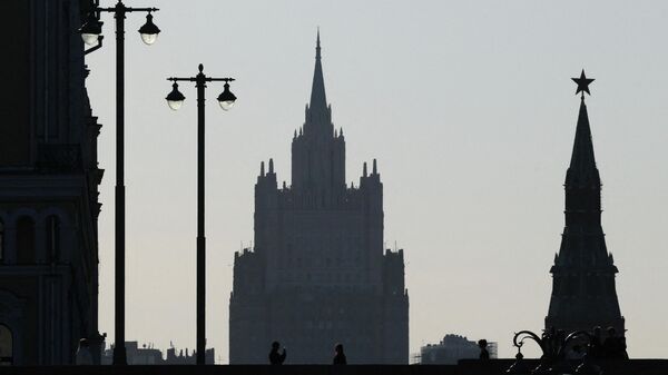 People take pictures on a bridge, with the headquarters of the Russian foreign ministry and a tower of the Kremlin in the background, in Moscow, Russia, March 30, 2026. - Sputnik भारत