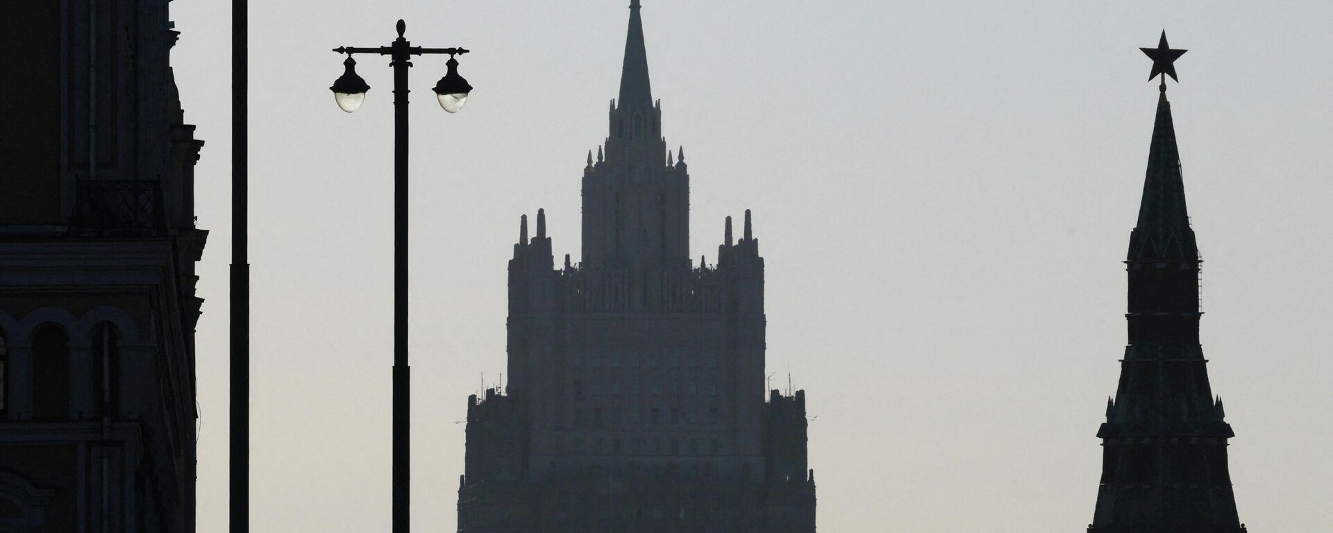 People take pictures on a bridge, with the headquarters of the Russian foreign ministry and a tower of the Kremlin in the background, in Moscow, Russia, March 30, 2026. - Sputnik भारत, 1920, 06.04.2026