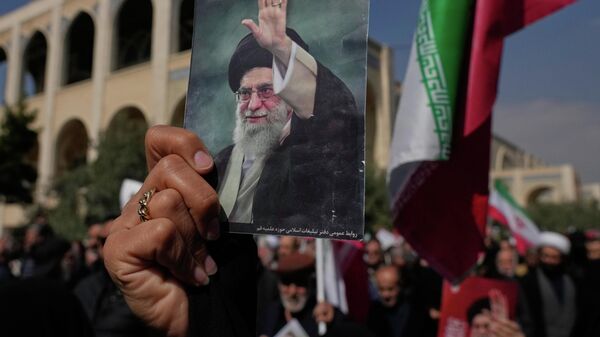 A woman holds up a picture of the late Iranian Supreme Leader Ayatollah Ali Khamenei as government supporters march against the ongoing U.S.-Israeli military campaign after Friday prayers at the Imam Khomeini Grand mosque in Tehran, Iran, Friday, March 6, 2026. (AP Photo/Vahid Salemi) - Sputnik India