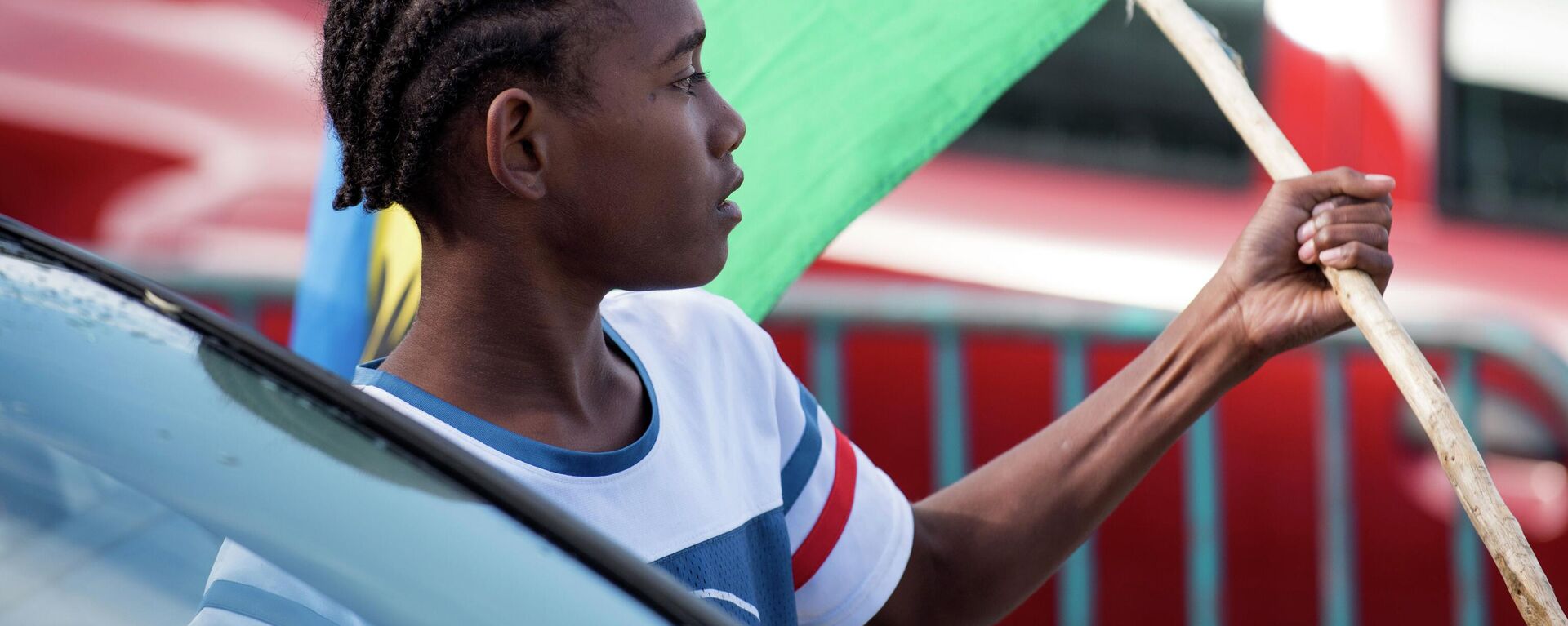 An Independence supporter holds the Kanak flag outside a voting station in the Riviere Salee district of Noumea, New Caledonia, Oct.4, 2020. - Sputnik भारत, 1920, 29.04.2026