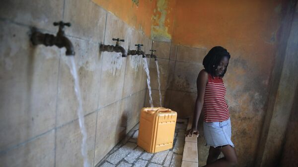 Девушка наполняет контейнер на заправочной станции в Порт-о-Пренсе, Гаити - Sputnik भारत