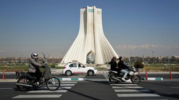 Vehicles drive by the Azadi (Freedom) monument in Tehran, Iran, Sunday, Feb. 22, 2026. - Sputnik भारत