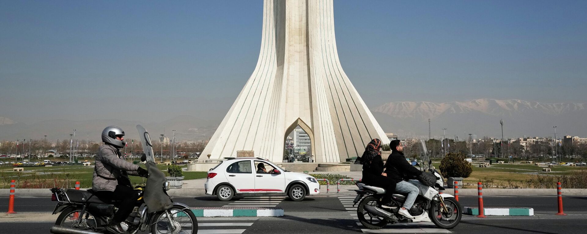 Vehicles drive by the Azadi (Freedom) monument in Tehran, Iran, Sunday, Feb. 22, 2026. - Sputnik भारत, 1920, 19.06.2026