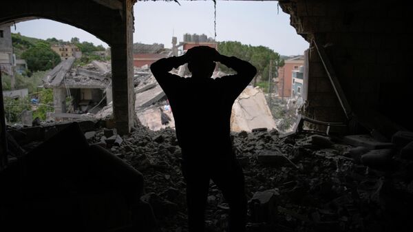 Assem Abdallah reacts as he enters his friend apartment destroyed in a Israeli airstrike in Kfar Roumman, southern Lebanon, Friday, April 17, 2026, following a ceasefire between Israel and Hezbollah. - Sputnik भारत