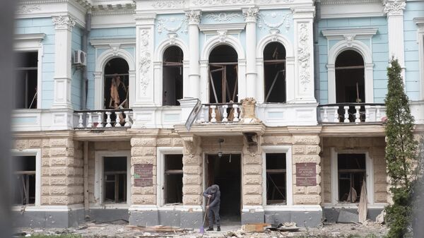 A man cleans a street from broken glass of a building damaged by a Russian missile strike on Sumy, Ukraine, Sunday, April 13, 2025. - Sputnik India