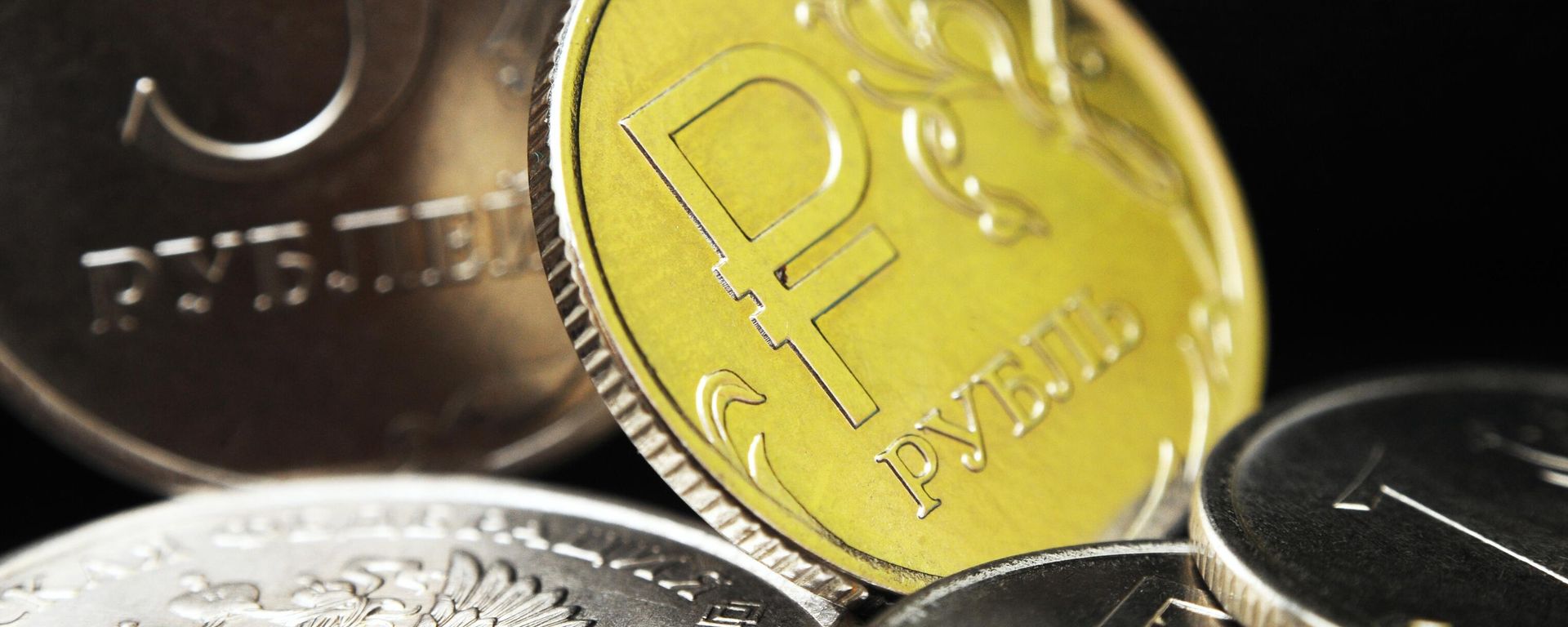 One ruble coin with the symbols of the Russian ruble. In the background is a Russian five-ruble coin One ruble coin with the symbols of the Russian ruble. In the background is a Russian five-ruble coin - Sputnik भारत, 1920, 30.05.2026