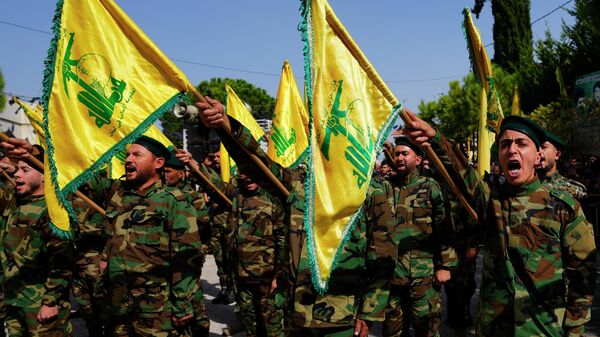 Hezbollah fighters rise their group's flag and shout slogans, as they attend the funeral procession of Hezbollah fighter, Bilal Nemr Rmeiti, who was killed by Israeli shelling, during his funeral procession in Majadel village, south Lebanon, Sunday, Oct. 22, 2023 - Sputnik India