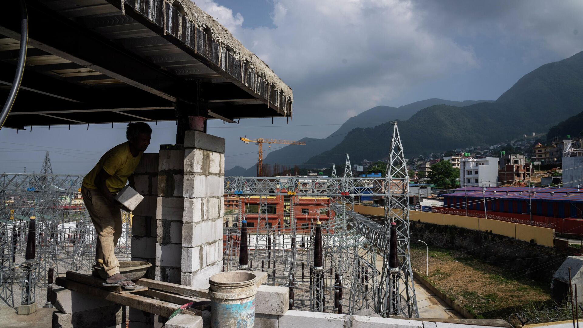 A laborer works at a construction site next to a power station at Matatirtha on the outskirts of Kathmandu, Nepal, Friday, May 31, 2024. Nepal’s abundant hydroelectric power is helping the Himalayan nation cut its oil imports and clean up its air, thanks to a boom in sales of electric vehicles. - Sputnik भारत, 1920, 06.06.2026